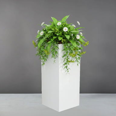 Perth Tall Corner Fiberglass Planter filled with plants against gray backdrop.