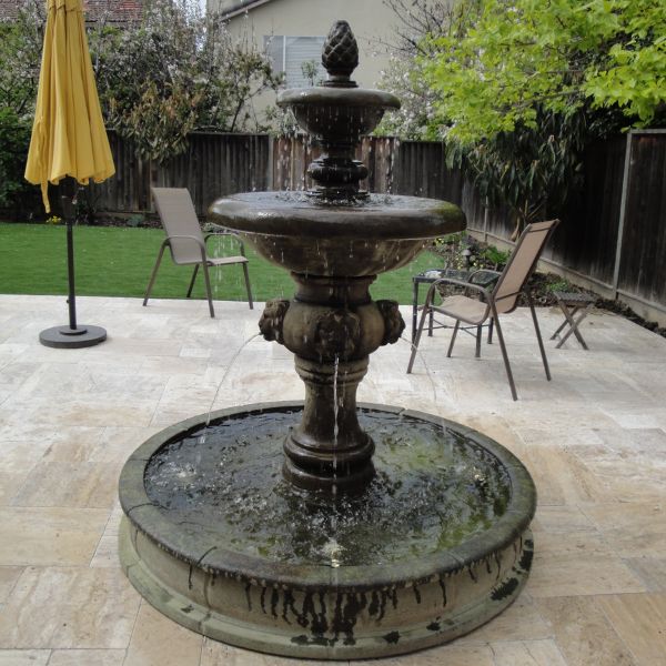 Quattro Lion Two Tier Pond Fountain on concrete in action.