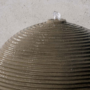 Ribbed Sphere Fountain on concrete in the backyard upclose