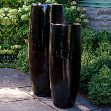 Sabine Planter, Tall - Flint - S/1 on concrete beside plants