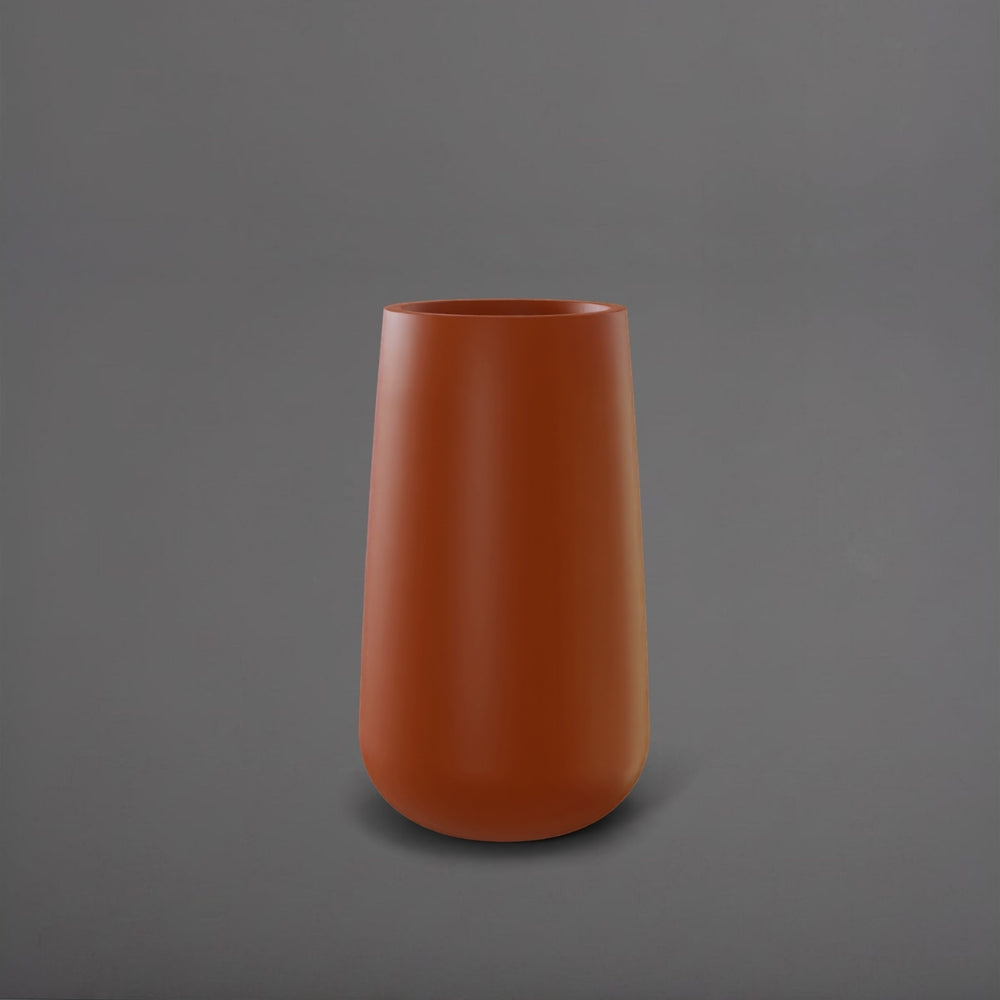 Saigon Tapered Round Fiberglass Planter in matte terra cotta against gray background.