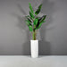 Saint Tropez Tall Bullet Round Fiberglass Planter on concrete filled with plants.