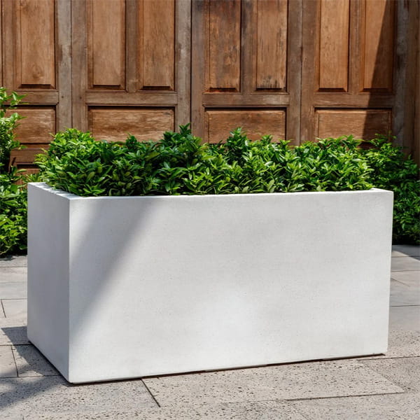 Sandal Planter S/1 in quartz premium on concrete filled with plants.