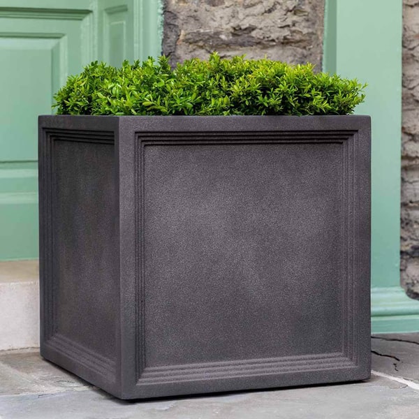 Campania International Sandhurst Square Planter, Extra Large on concrete filled with plants.