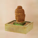 Serene Buddah Fountain against brown background.