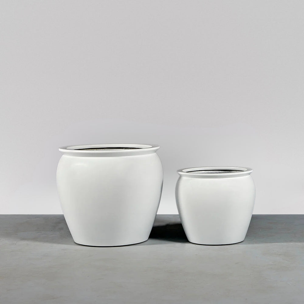 Shanghai Fishbowl Fiberglass Planter on concrete shown with different sizes.