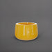 Short Hayden Tapered Round Fiberglass Planter in gloss saffron against gray background.