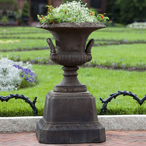 Smithsonian Egg and Dart Pedestal on concrete with flowers