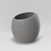 Spiral Globe Fiberglass Planter in matte cement grey against gray background.