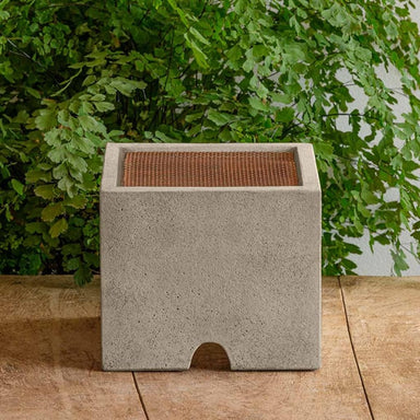 Splash Guard Square Wide on table against green leaves.