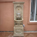 St. Helena Urn Fountain against brown wall.