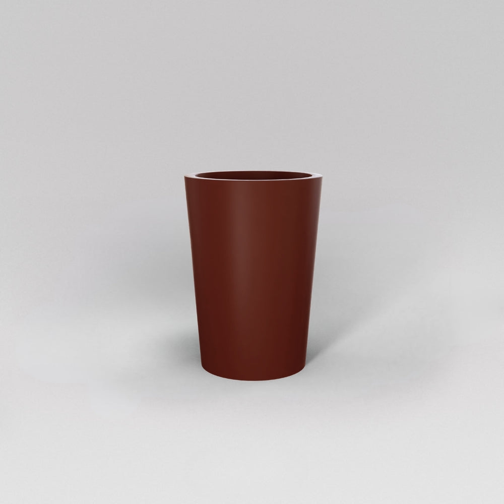 Tagel Tapered Round Fiberglass Planter in matte terra cotta against gray background.