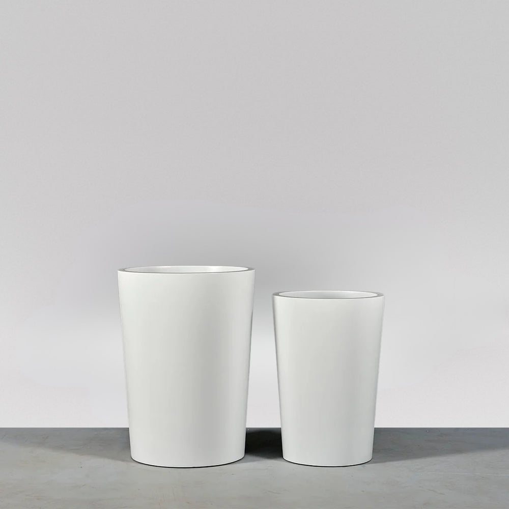Tagel Tapered Round Fiberglass Planter on concrete shown in different sizes.