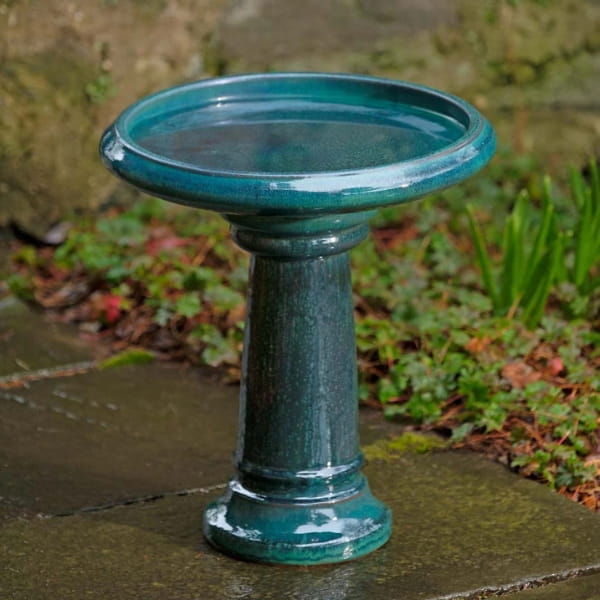 Terrace Birdbath in indigo rain on concrete in the backyard.
