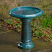 Terrace Birdbath in indigo rain on concrete in the backyard.