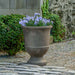 Textured Pascal Urn filled with purple flowers in the backyard