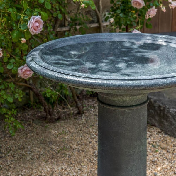 The Hampton Birdbath on gravel in the backyard upclose