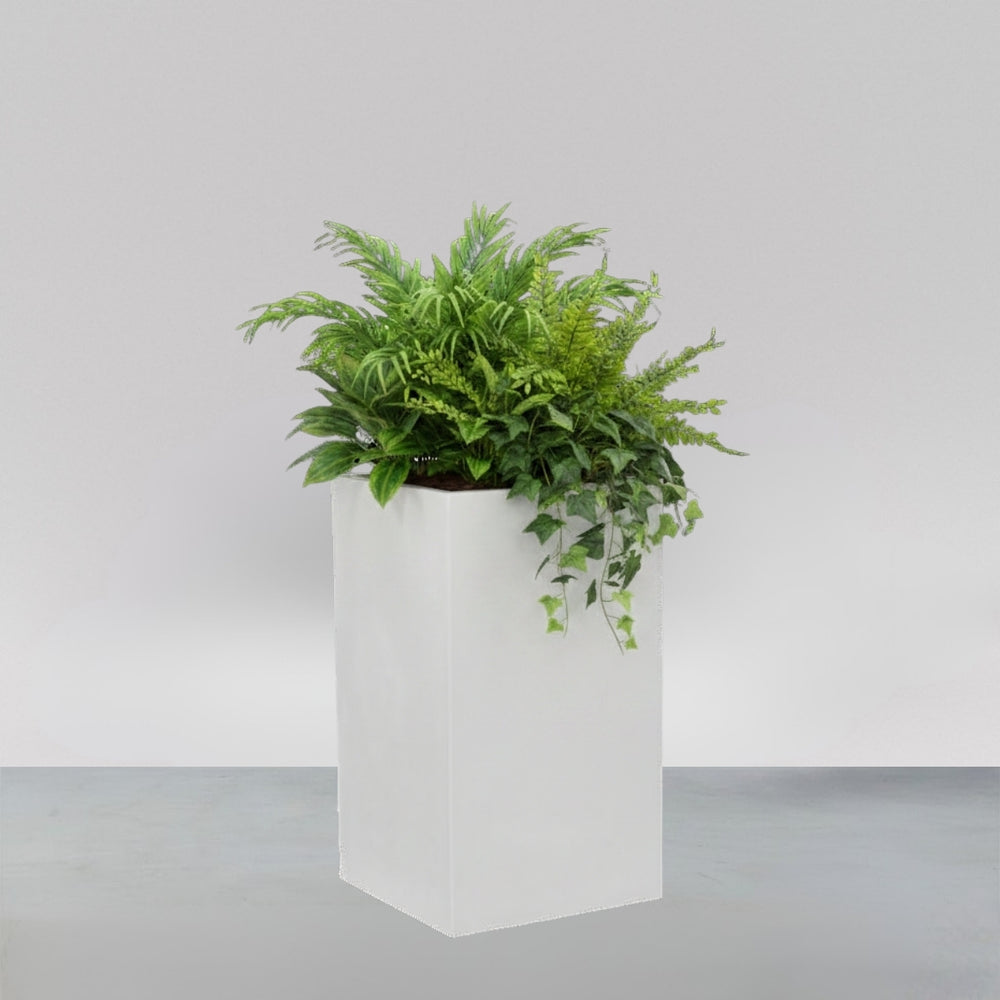 Torino Corner Fiberglass Planter filled with plants against gray background.