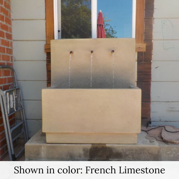 Tribus Wall Fountain in french limestone color against the house window.