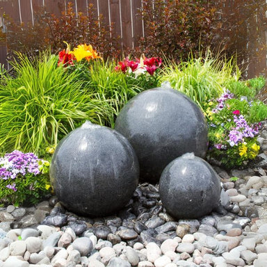 Triple Black Granite Sphere Fountain Kit on black peeble against green leaves