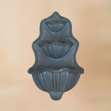 Vicentina Wall Fountain against brown background.