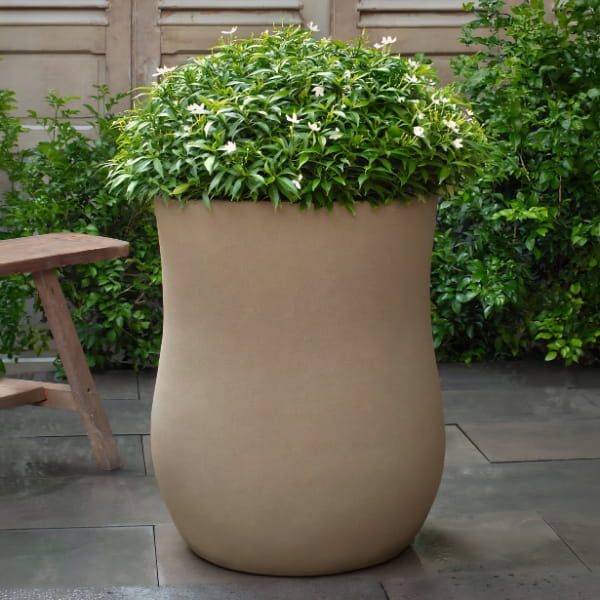 Vigneto Planter in glazed ash color on concrete filled with plants.