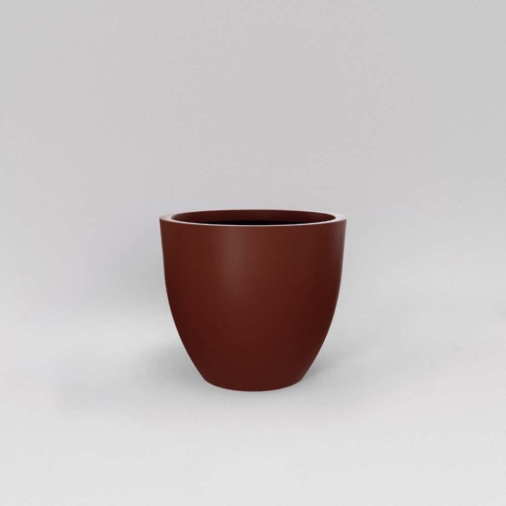 Wannsee Extra Large Round Fiberglass Planter in matte terra cotta against gray background.