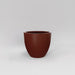Wannsee Extra Large Round Fiberglass Planter in matte terra cotta against gray background.