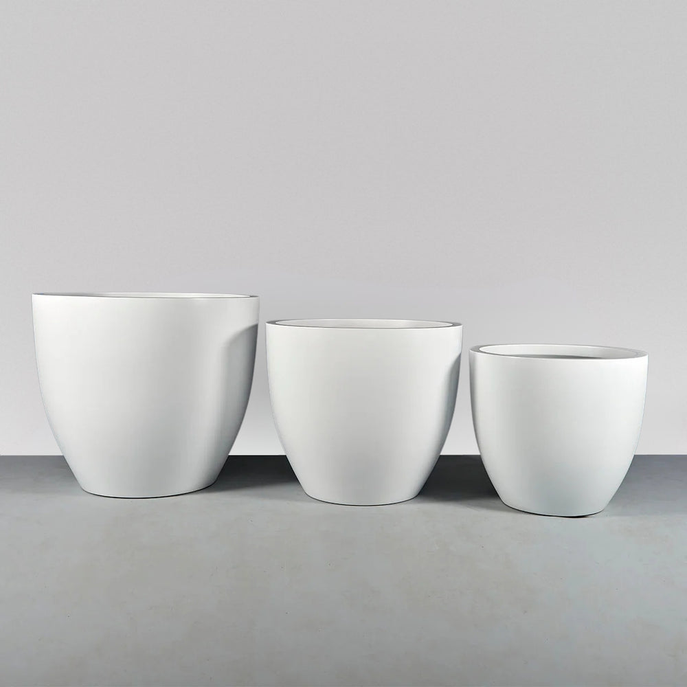 Wannsee Extra Large Round Fiberglass Planter on concrete shown with different sizes.