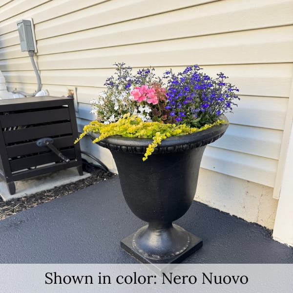 Williamsburg Egg and Dart urn planter in black finish filled with flowers near entrance to home.
