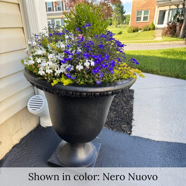 Williamsburg Egg and Dart planter in black finish filled with colorful flowers near home front entrance.