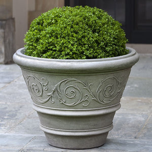 Arabesque Rolled Rim Planter on concrete patio filled with plants