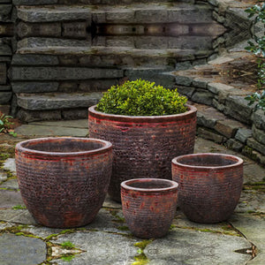 Aspara Planter - Angkor Red - Set of 4 filled with plants in the backyard