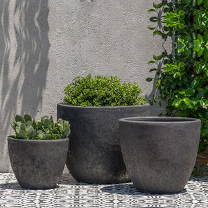 Caipirinha Planter Volcanic Coral S/3 filled with plants against wall 