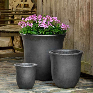 campana-planter-graphite-s-3-on-concrete-filled-with-purple-flowers