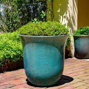 Campana Planter Weathered Copper S/3 on concrete filled with plants