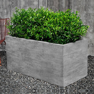 Chenes Brut Long Box Planter on gravel filled with plants