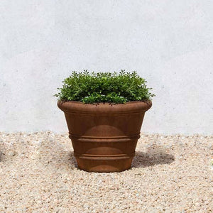 Classic Rolled Rim 14.75" Planter on gravel against wall in the backyard
