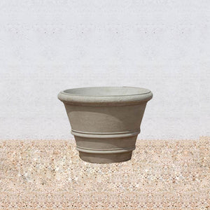 Classic Rolled Rim 27" Planter on gravel against cream wall