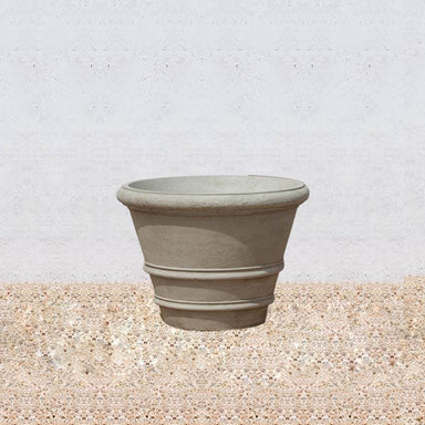 Classic Rolled Rim 27" Planter on gravel against cream wall