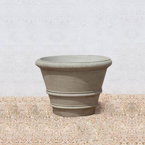Classic Rolled Rim 27" Planter on gravel against cream wall
