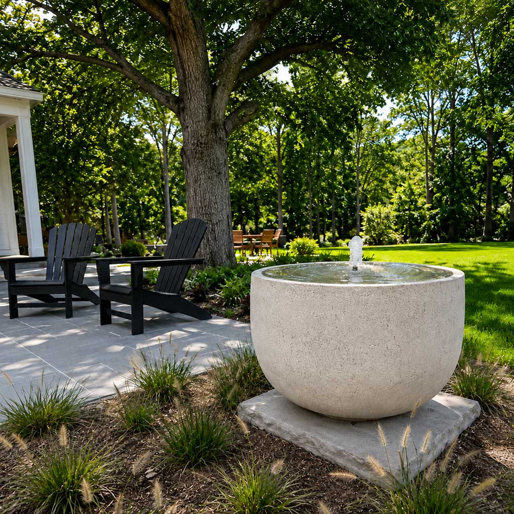 Echo park fountain in action in backyard near two black adirondack chairs