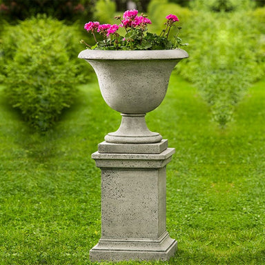 Fairfield Urn on pedestal filled with pink flowers in the backyard