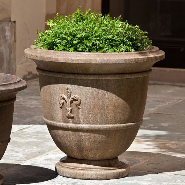 Fleur de Lis Large Urn on concrete patio filled with plants