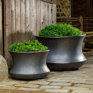 Jura Planter Graphite S/2 filled with plants near chair