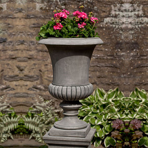Kent Urn filled with plants against concrete wall upclose