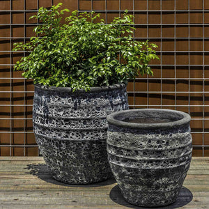 Knossos Planter Fossil Grey S/2 filled with plants on wood floor