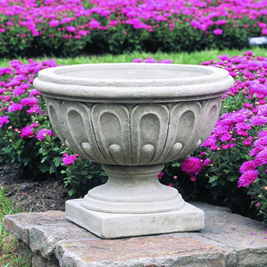 Longwood Fluted Urn near magenta flowers in the backyard