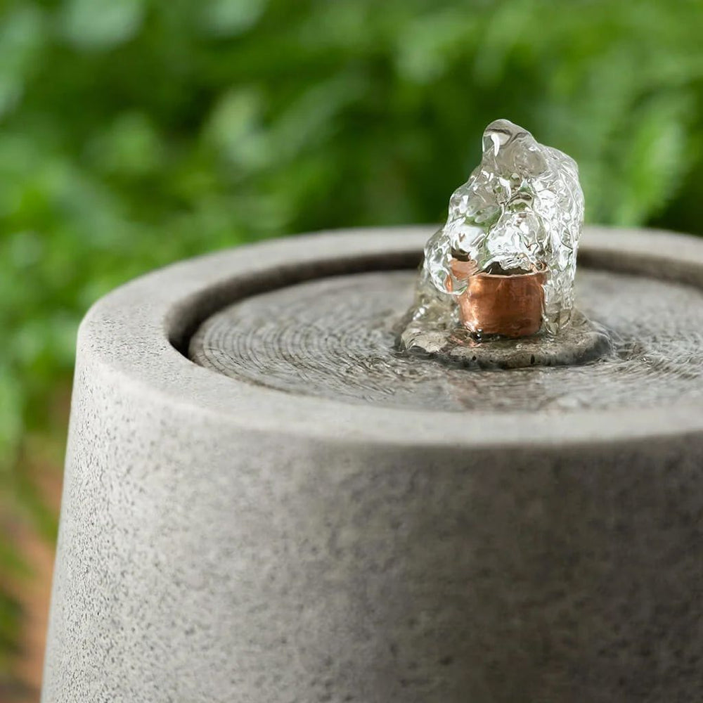 Mari Fountain in action against in the green plants upclose