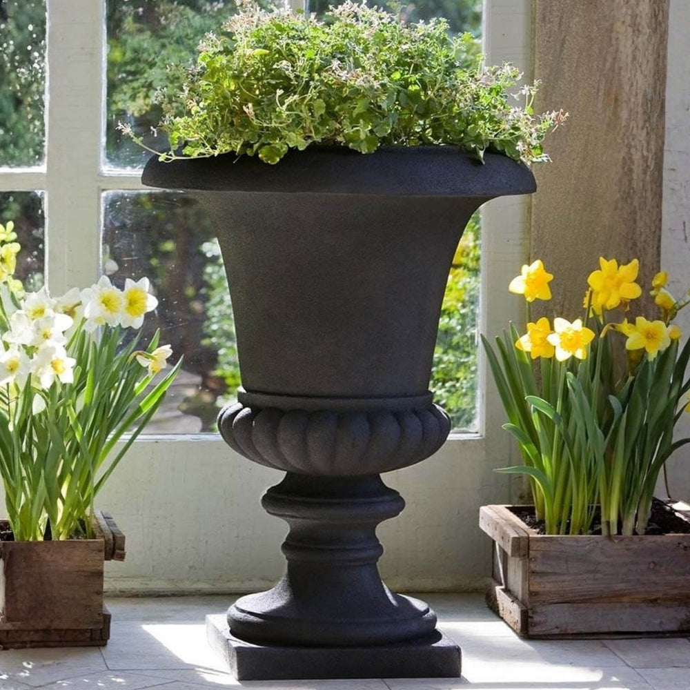 Morganna Lite Urn - Onyx Black Lite - S/1 on concrete filled with plants